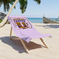 Kickin’ Cancer mint beach towel with western boot and awareness-ribbon artwork, folded over a wooden beach chair on sand.