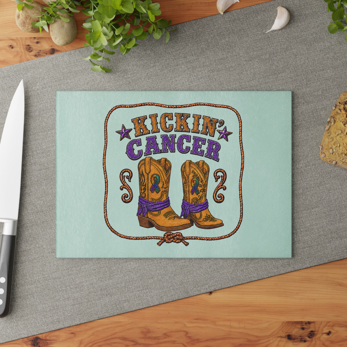 Mint tempered glass cutting board with cowboy boots and Kickin' Cancer design on a kitchen counter