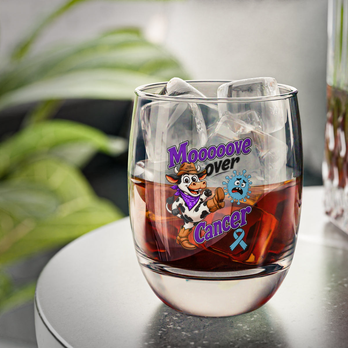 Moooove Over Cancer whiskey glass shown with a drink and ice, featuring a colorful cow design