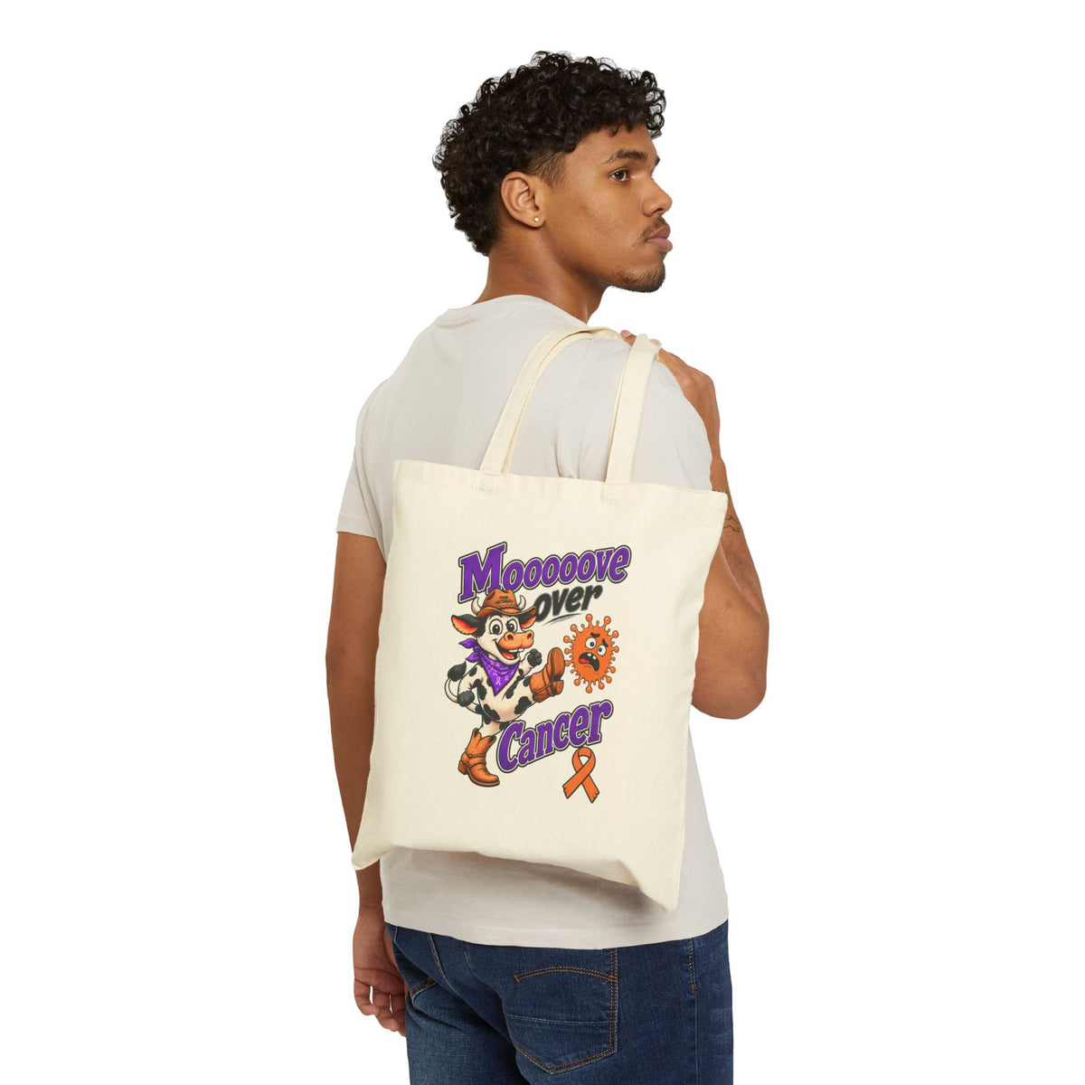 Person wearing a natural Moooove Over Cancer canvas tote over one shoulder
