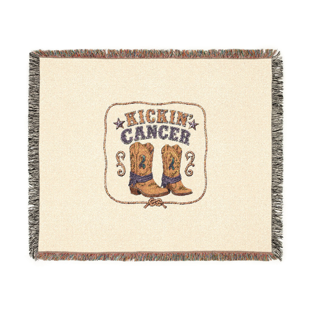 Flat-lay view of the Kickin' Cancer woven throw with cowboy boots and a colorful fringed border