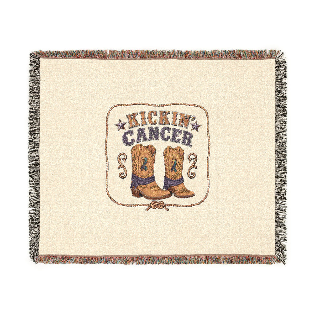 Flat-lay view of the Kickin' Cancer woven throw with cowboy boots and a colorful fringed border