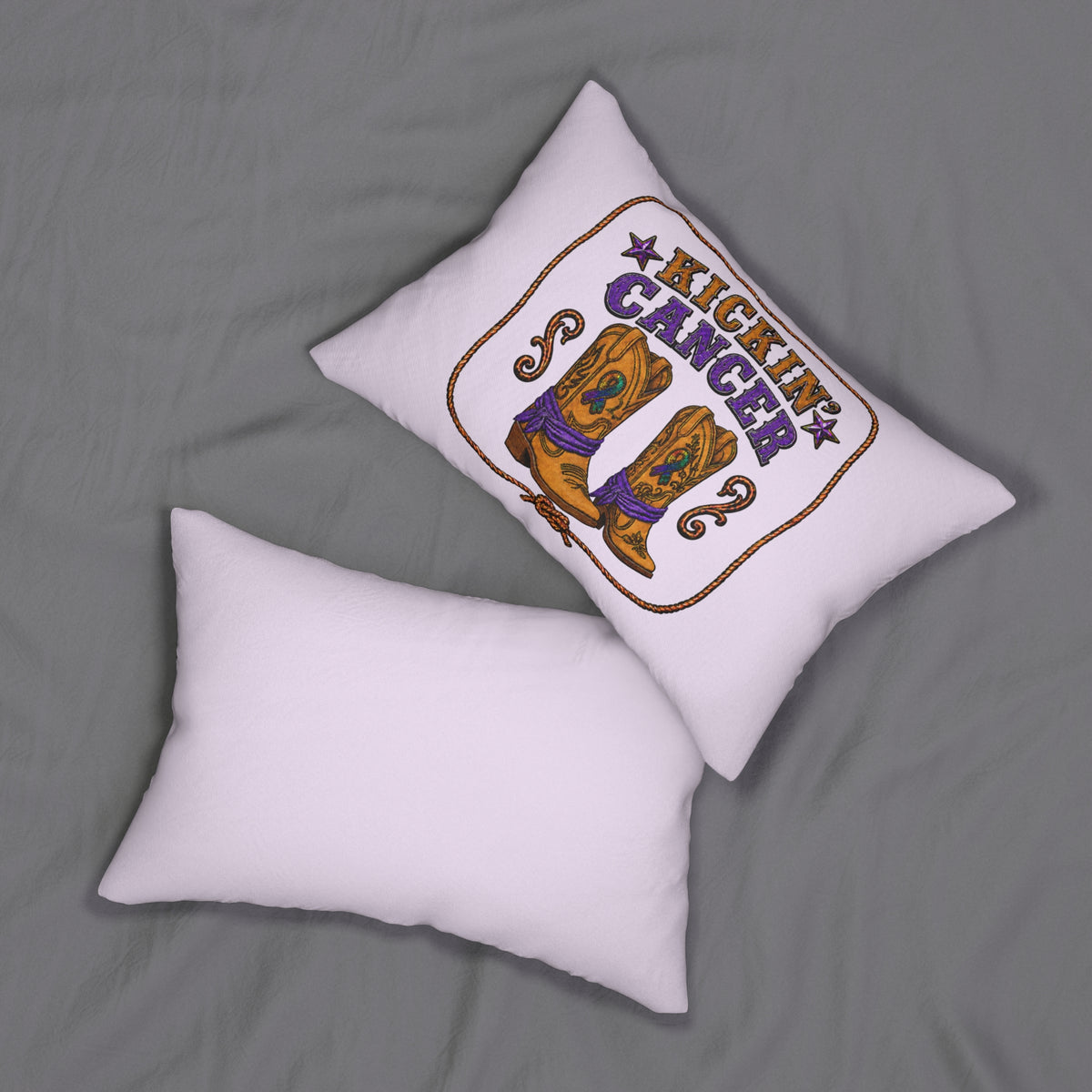 Kickin' Cancer lumbar pillow shown on a bed beside a plain lavender pillow