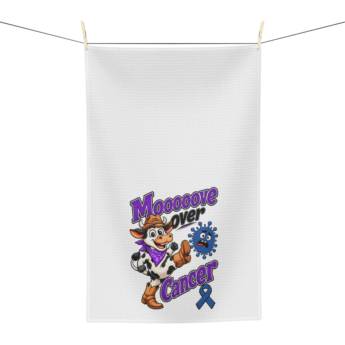 Moooove Over Cancer tea towel hanging on a line with colorful cowgirl-and-cow artwork