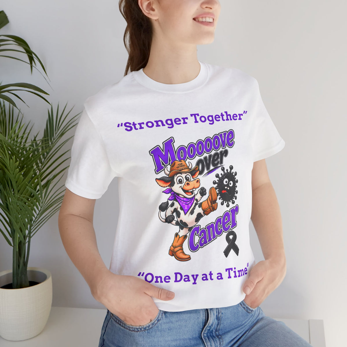 Woman wearing a white Moooove Over Cancer T-shirt with Melanoma Cancer awareness ribbon