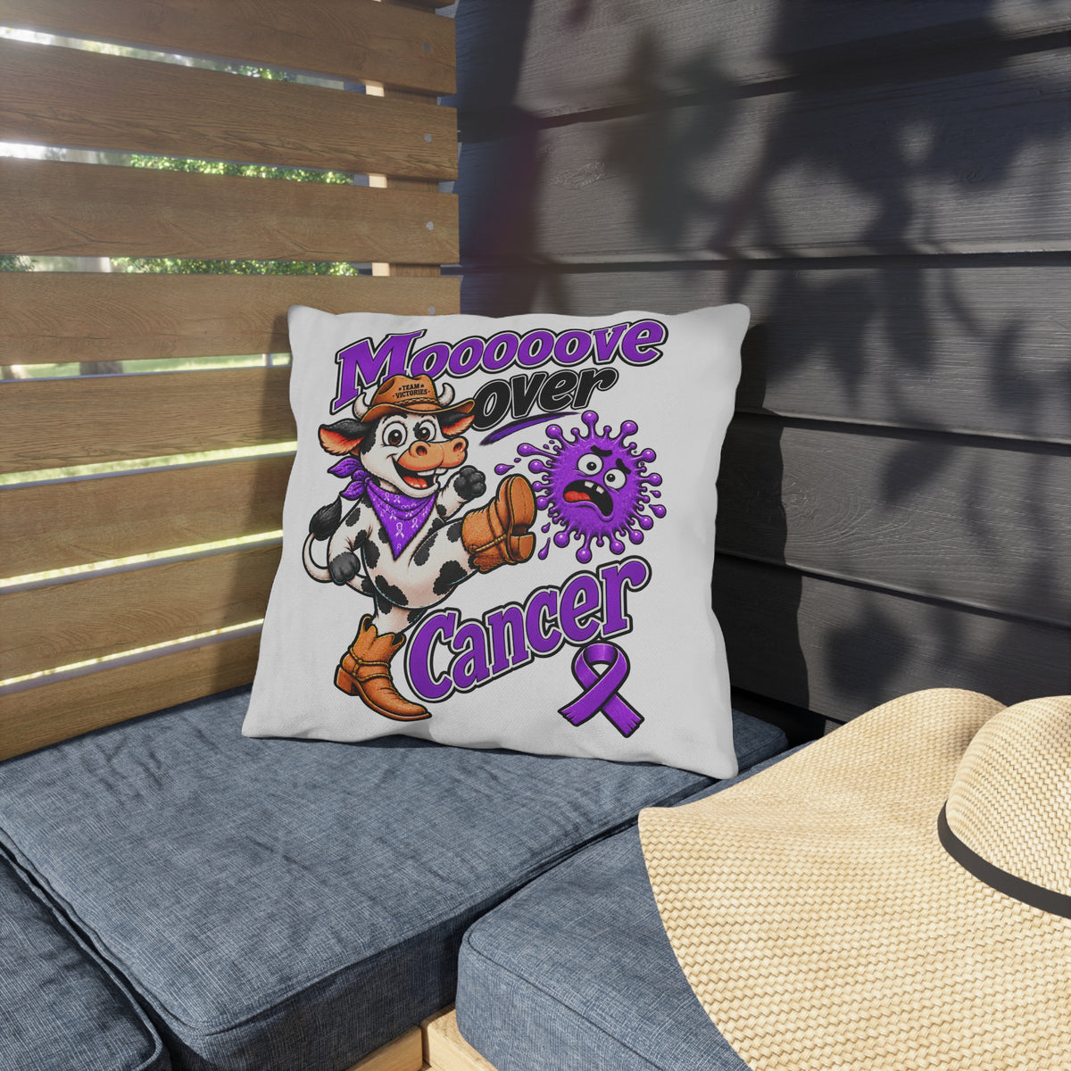 Moooove Over Cancer pillow on an outdoor lounge chair with purple ribbon design