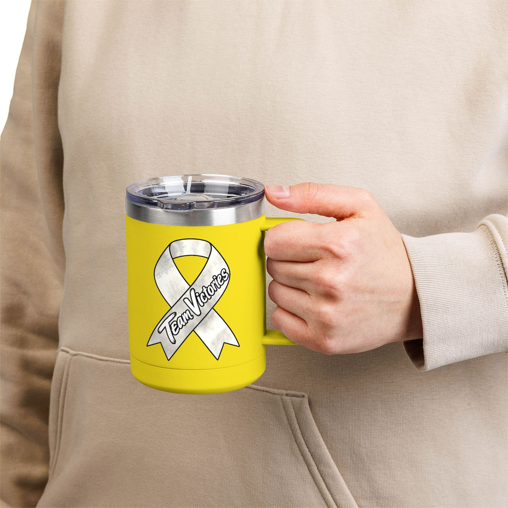 Person holding a yellow Team Victories mug with a Lung Cancer awareness ribbon