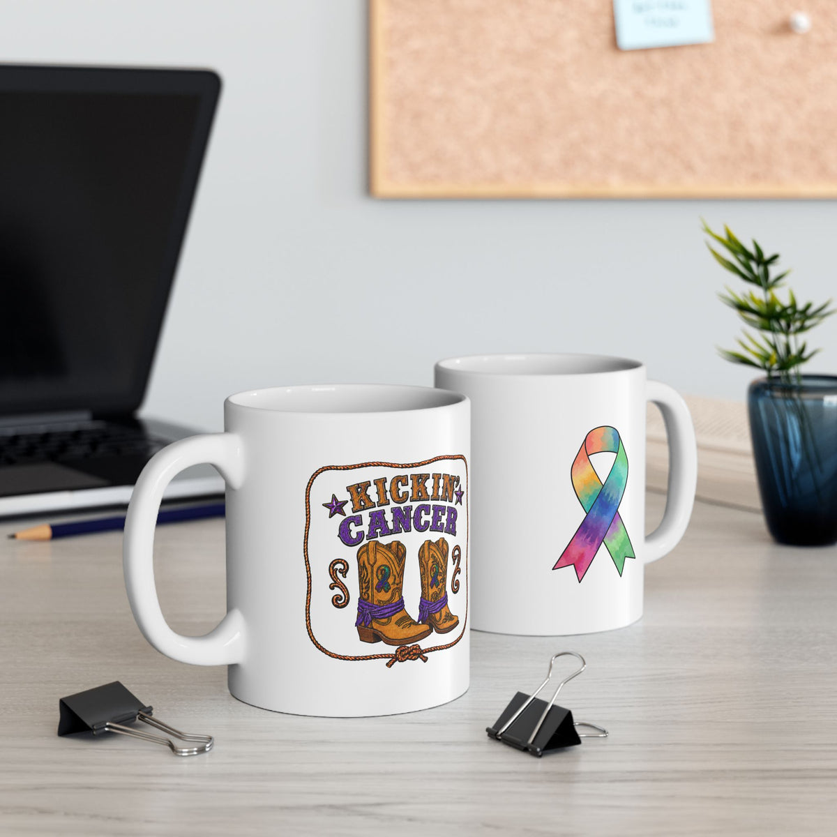 Kickin’ Cancer mug showing boot and ribbon designs on a desk