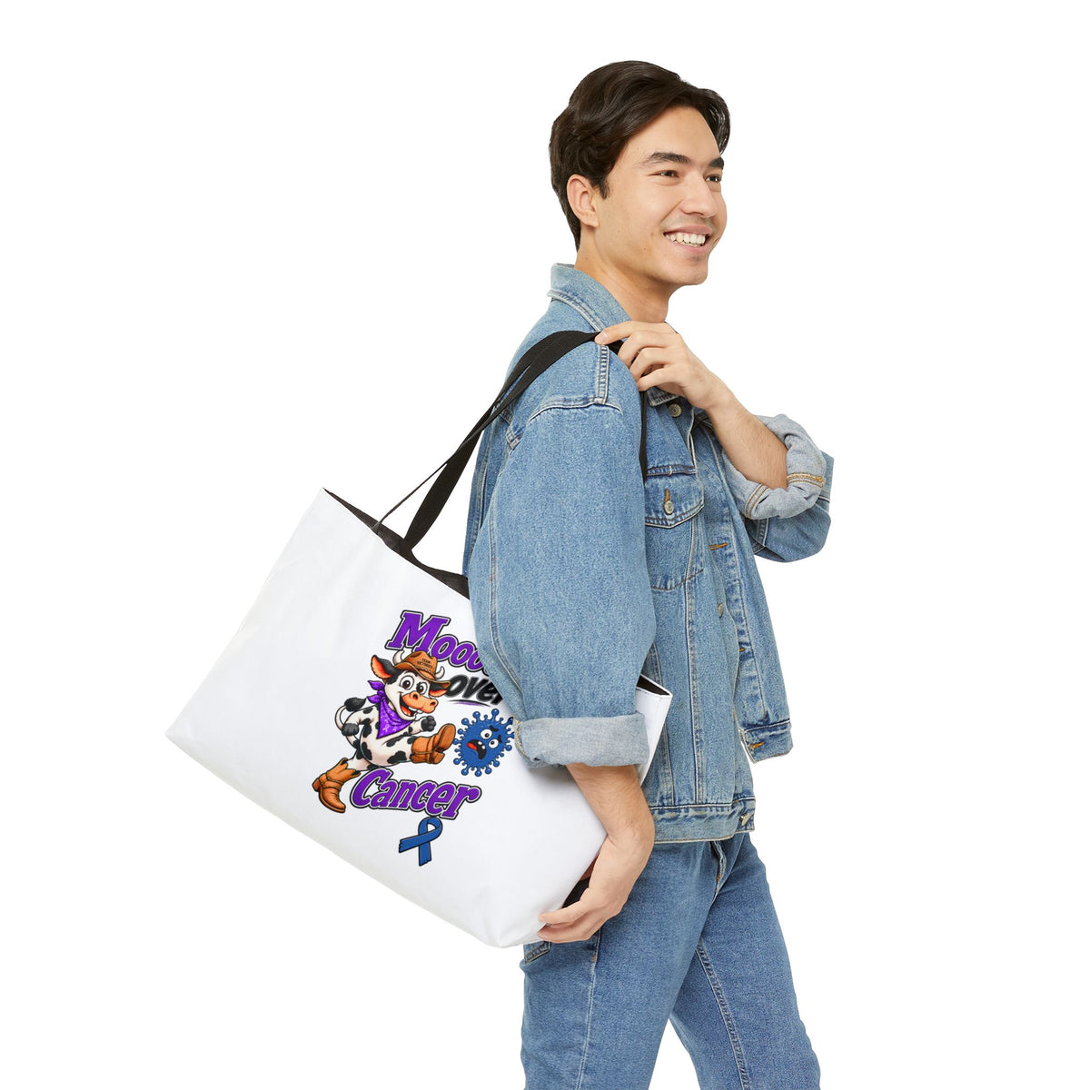 Moooove Over Cancer white tote carried by a person, showing the colorful cow artwork