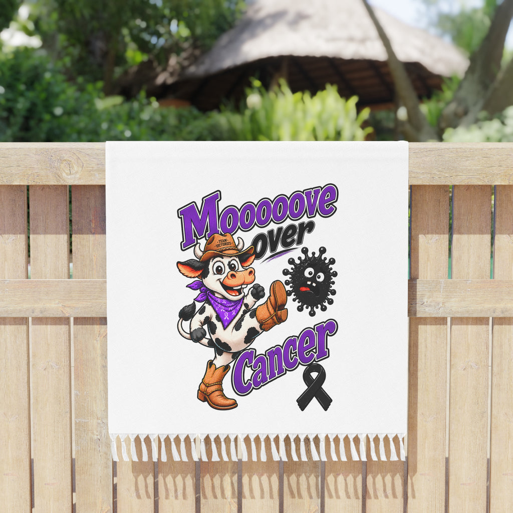 Mooove Over Cancer towel with tasseled edges hanging on a fence