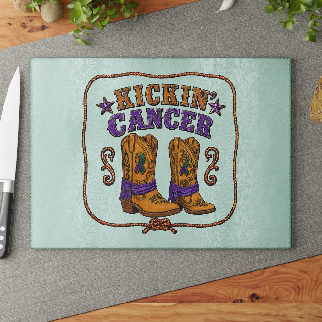 Kickin' Cancer glass cutting board on a gray placemat with kitchen ingredients