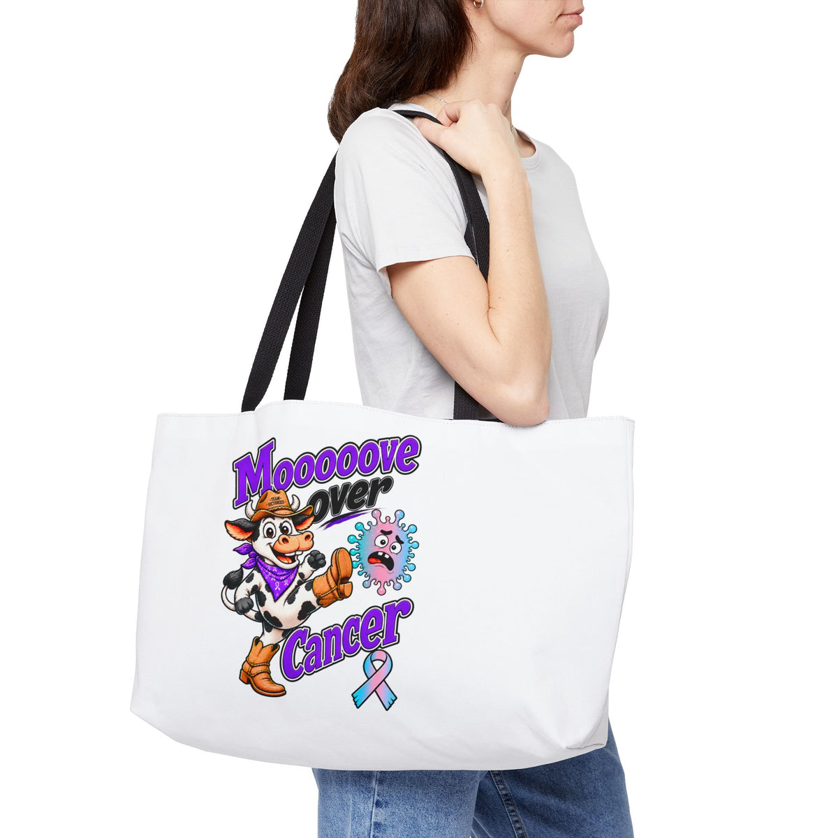 Moooove Over Cancer weekender tote shown on a shoulder with black webbing handles