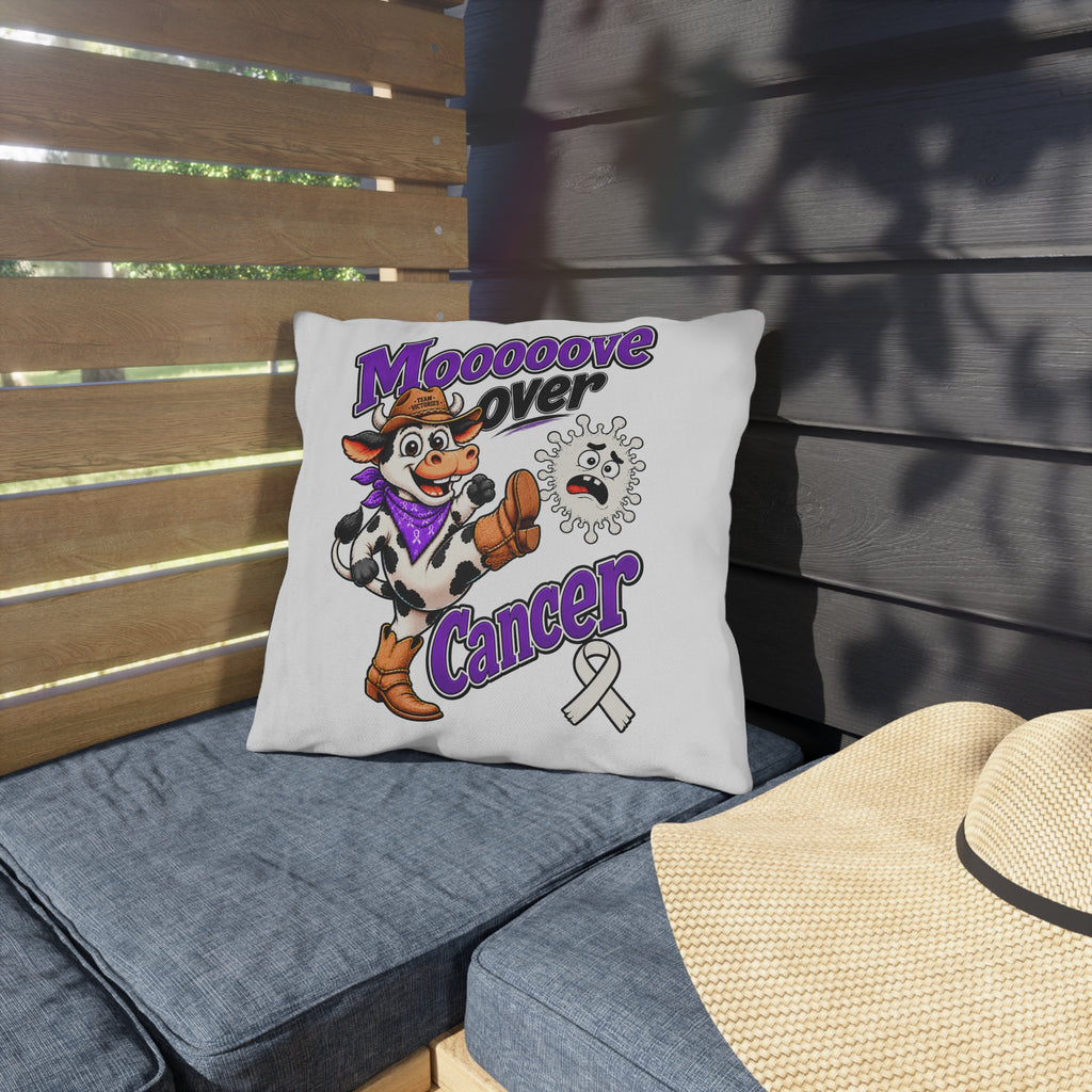 Moooove Over Cancer decorative pillow on a patio seat, showing the cow and cancer awareness ribbon