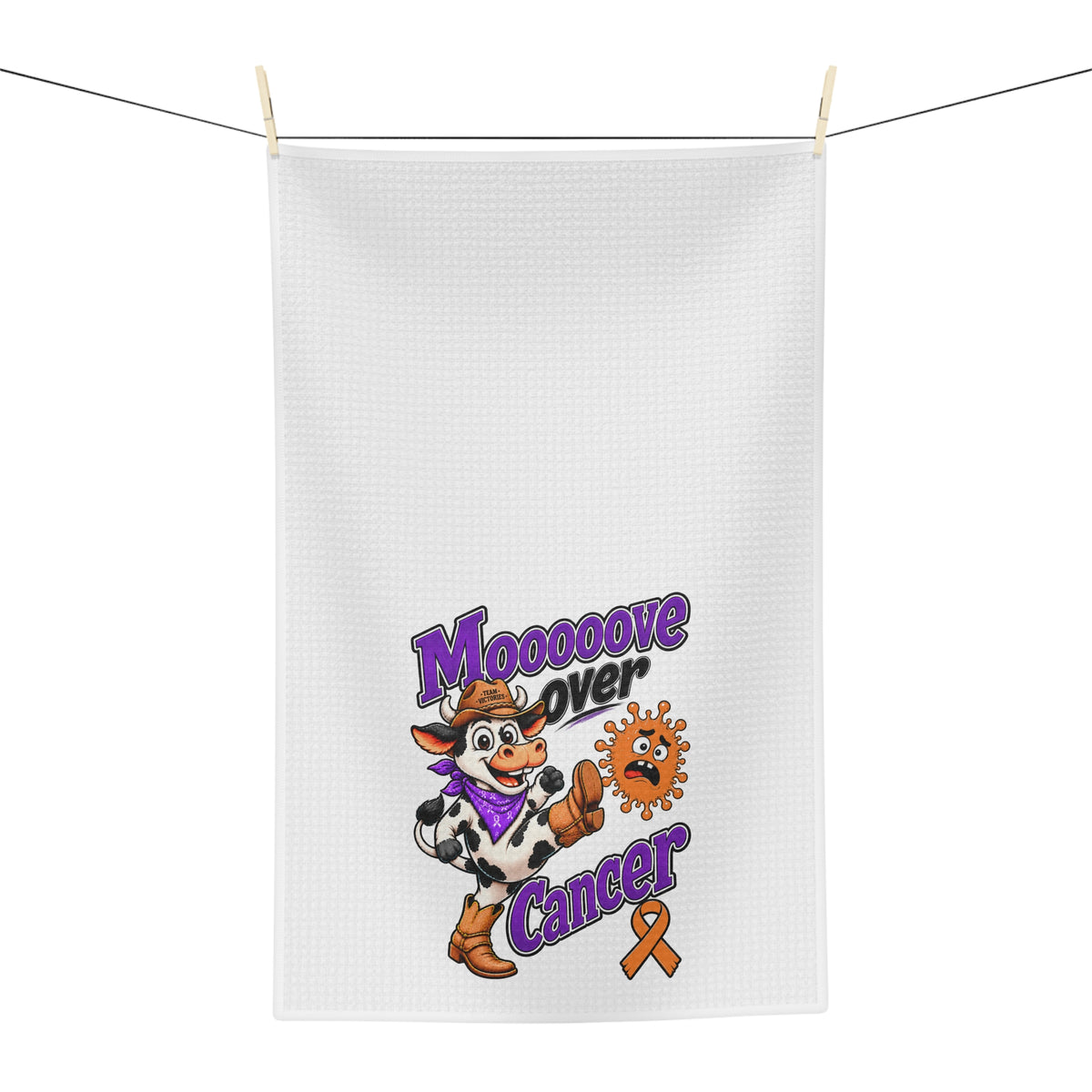 Moooove Over Cancer tea towel hanging on a line with playful cow design