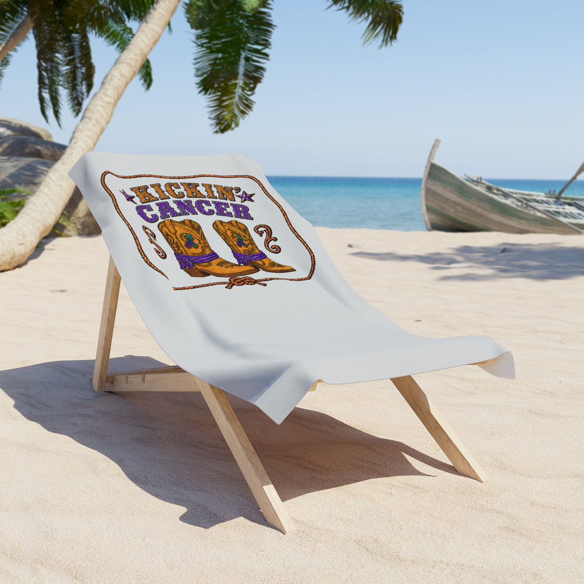 Kickin' Cancer beach towel with western boot artwork on a beach lounge chair
