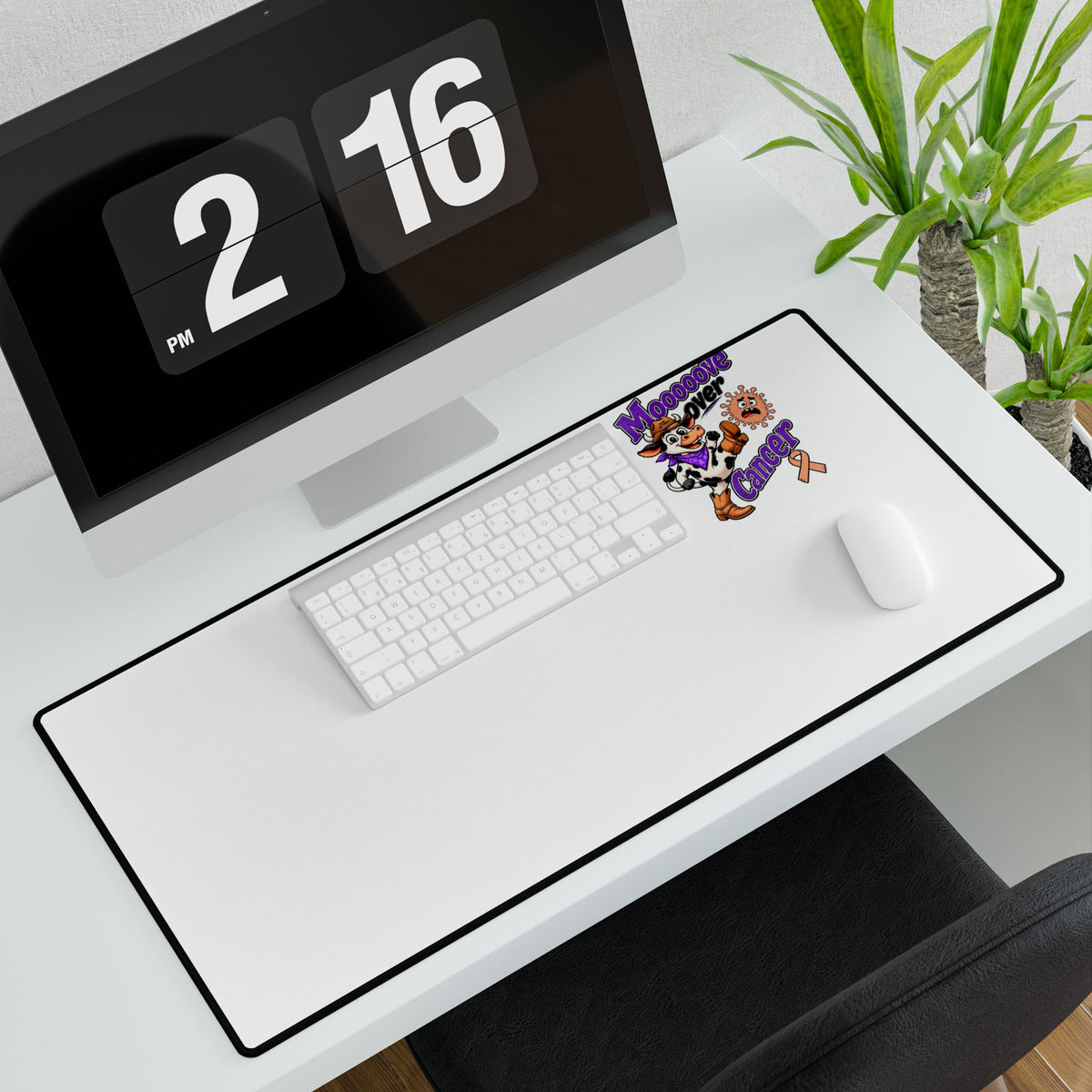 Moooove Over Cancer desk mat with keyboard and mouse on a white workstation