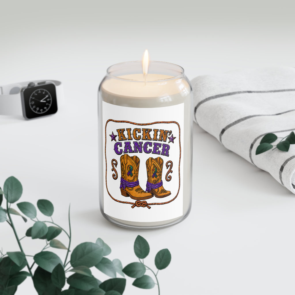 Kickin' Cancer soy candle with western boot artwork beside a clock, houseplant, and folded blanket