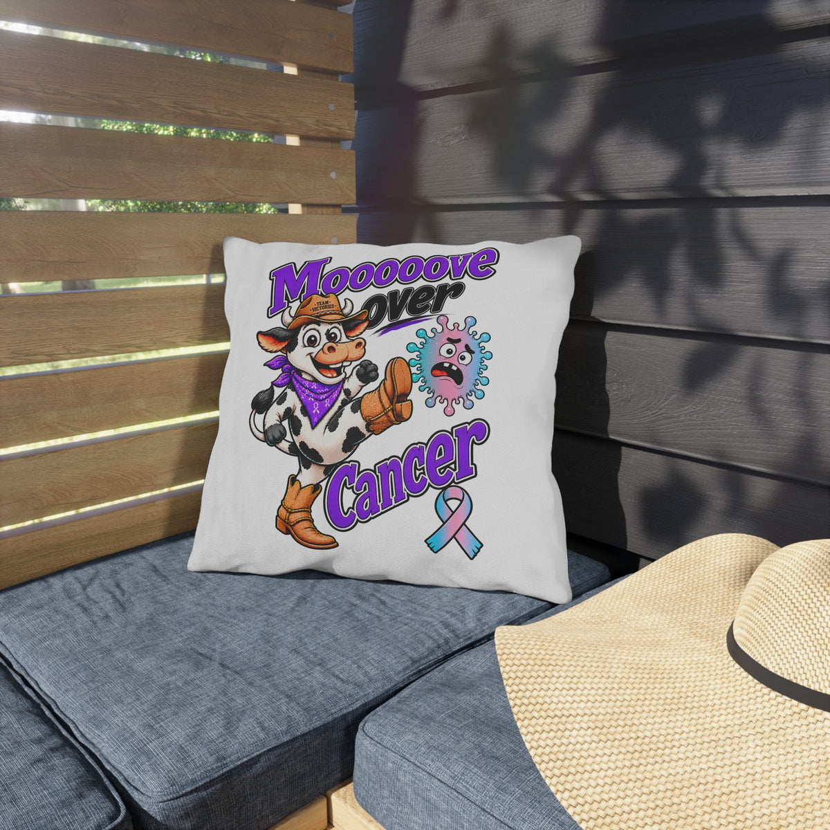 Moooove Over Cancer decorative pillow on an outdoor seat with colorful cow artwork