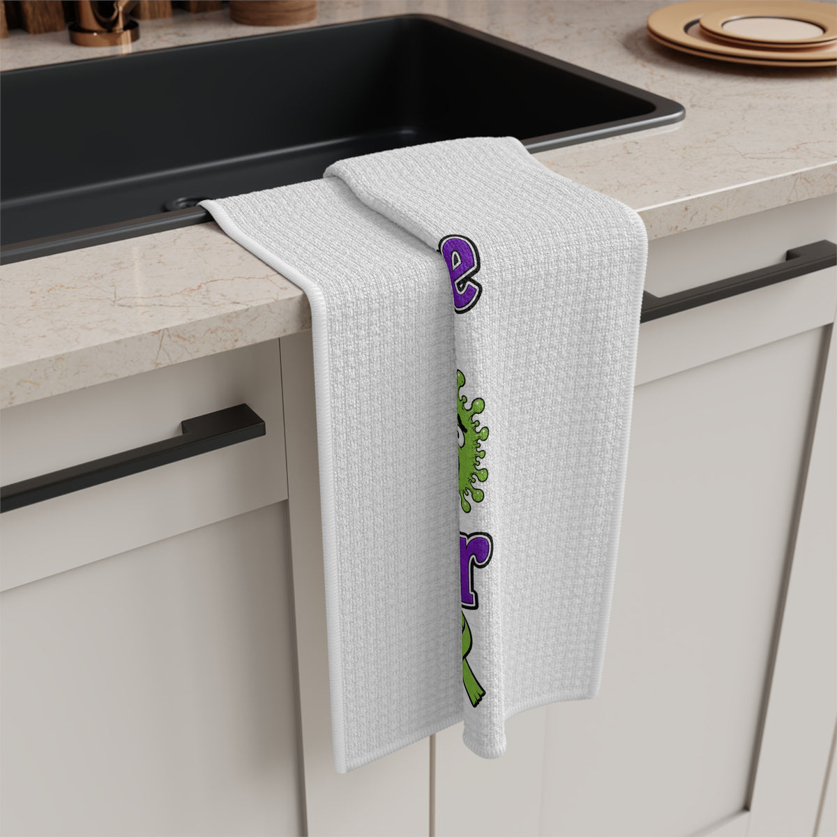 Moooove Over Cancer tea towel draped over a counter with colorful cow design visible