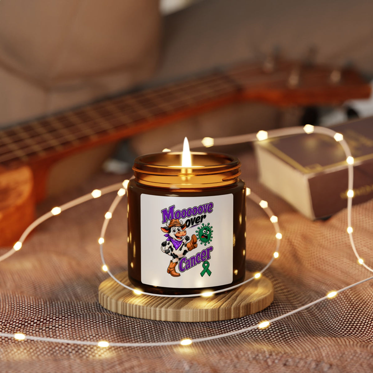 Lit Moooove Over Cancer amber candle displayed with its Liver Cancer awareness ribbon design