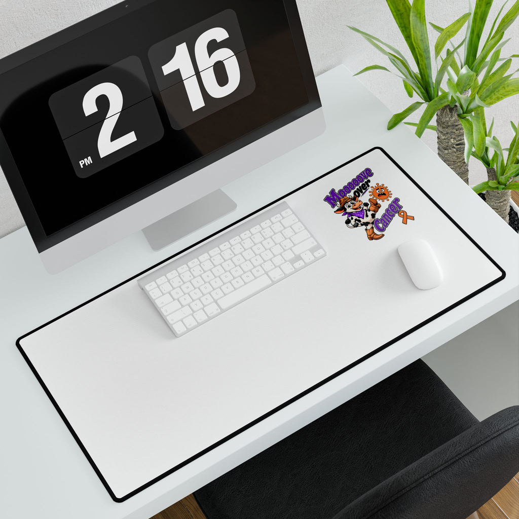 Moooove Over Cancer desk mat shown with keyboard and mouse on a modern workspace