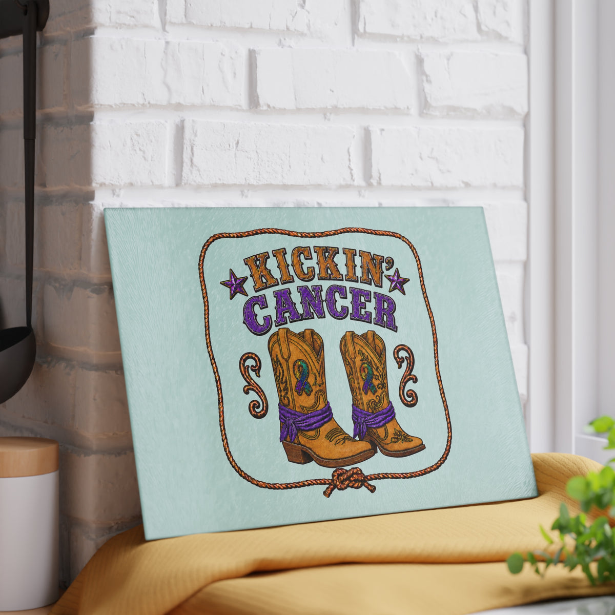 Kickin' Cancer tempered glass cutting board displayed against a white brick wall