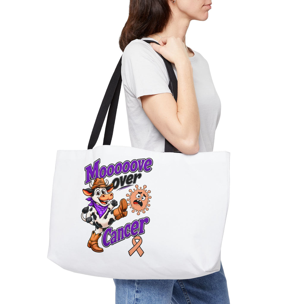 Model carrying the Moooove Over Cancer colorful awareness weekender tote bag