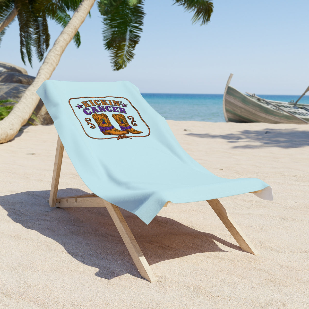 Powder Blue Kickin' Cancer towel draped over a beach chair on a sunny beach