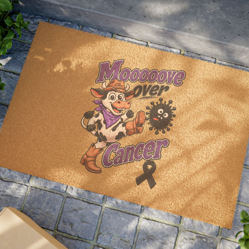 Moooove Over Cancer coir welcome mat displayed at an entryway with a black ribbon design