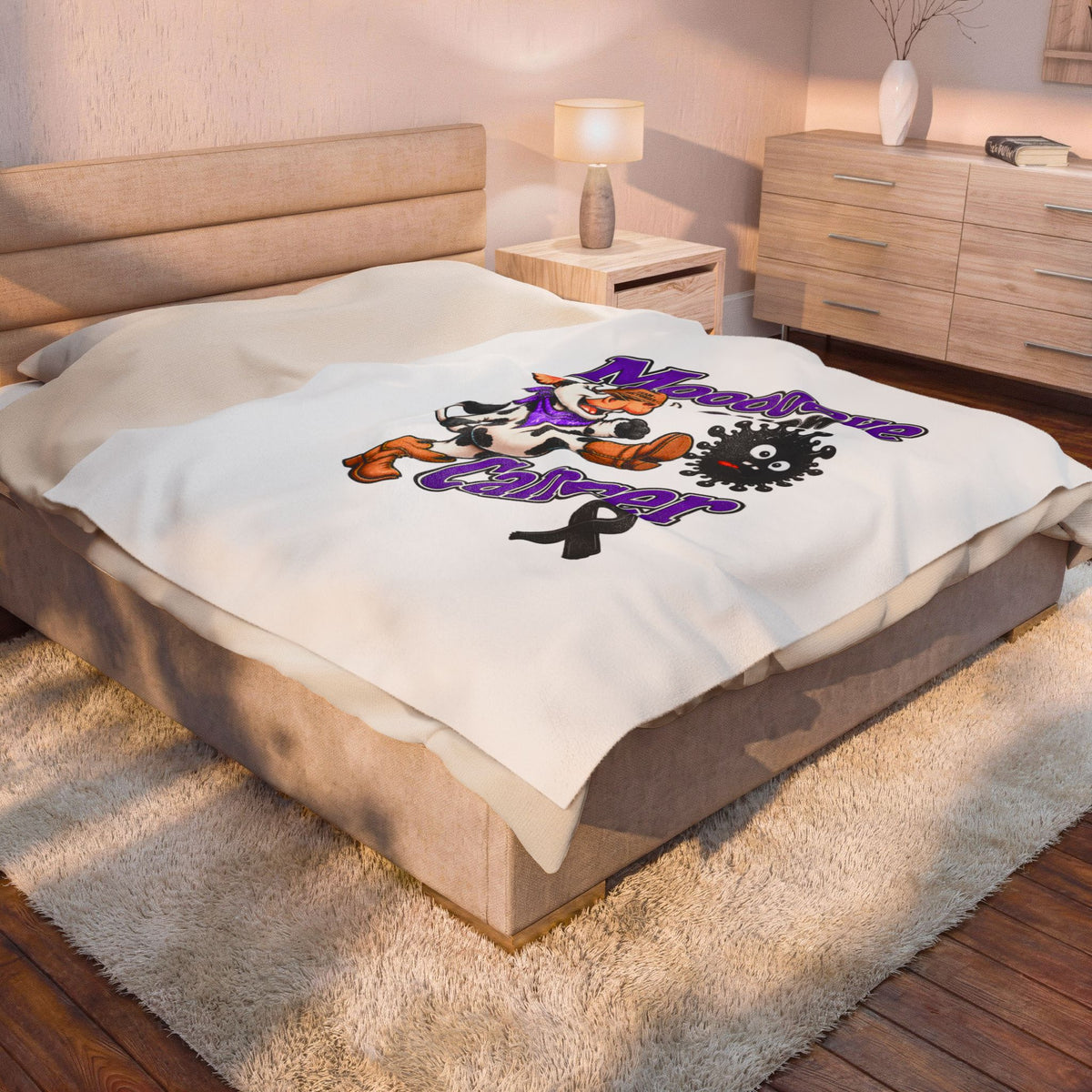 Moooove Over Cancer blanket styled across a bedroom bed in a horizontal view