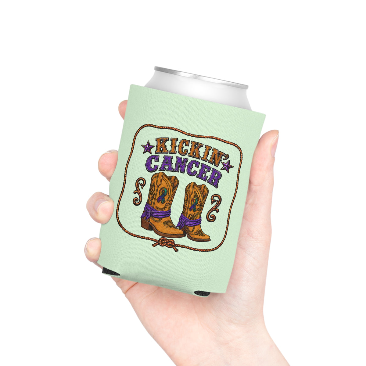 Hand holding a Kickin’ Cancer light green can cooler with western boot and awareness-ribbon artwork.