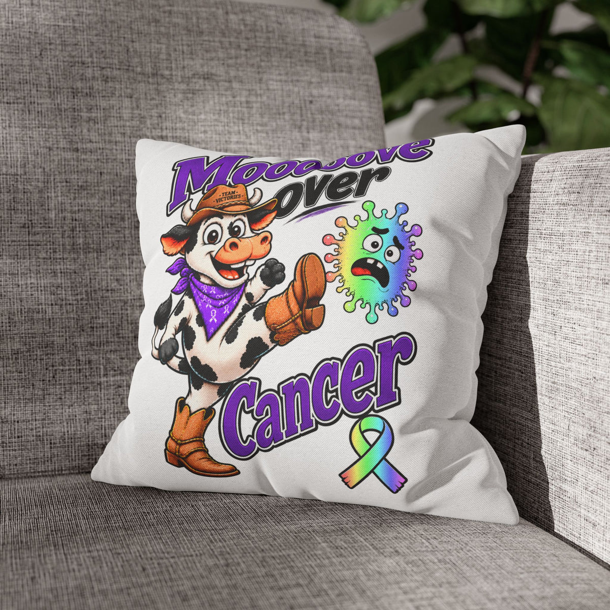 Moooove Over Cancer pillow case styled on a gray couch with cow artwork and awareness ribbon