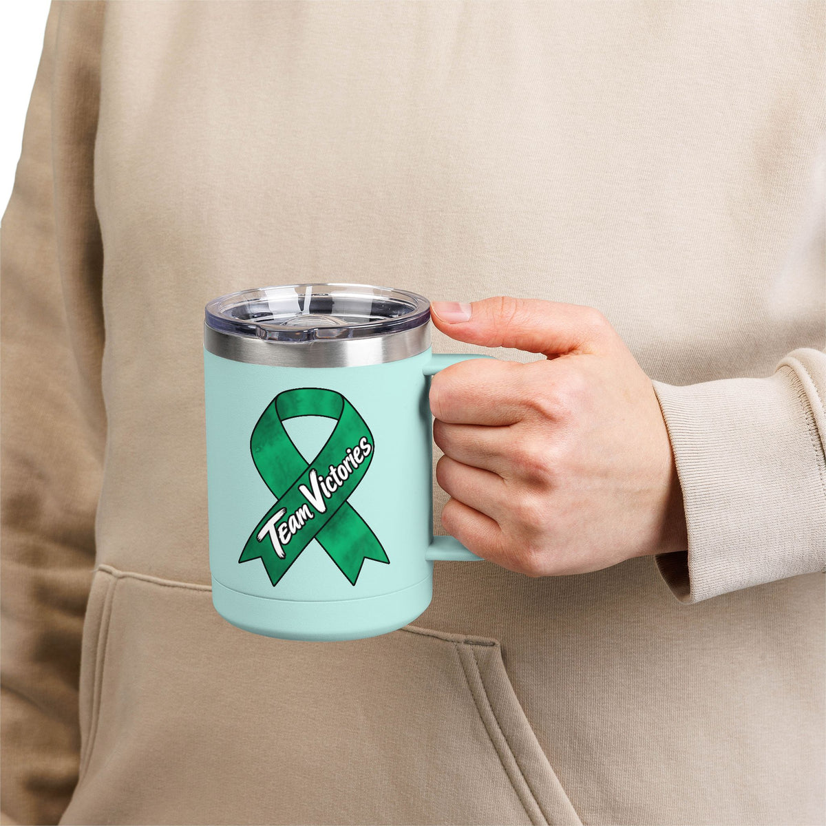 Person holding mint Team Victories mug with green Liver Cancer awareness ribbon