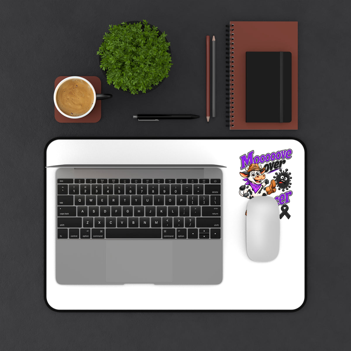 Moooove Over Cancer desk mat under a laptop and mouse, featuring a Melanoma Cancer awareness ribbon