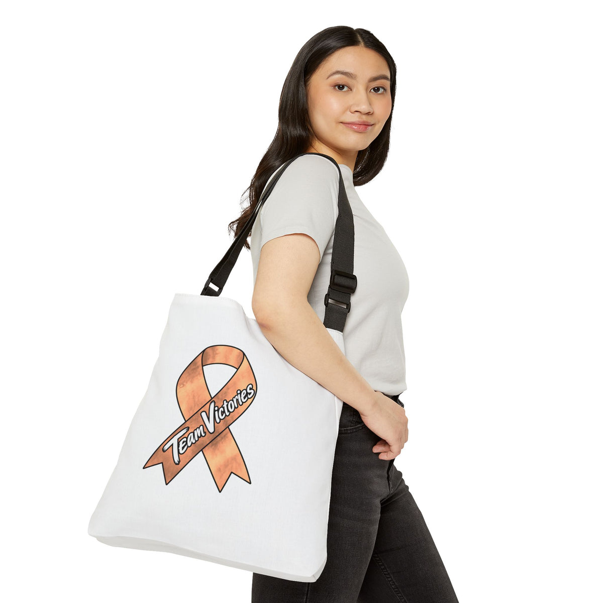 Side view of a person carrying the Team Victories orange ribbon tote