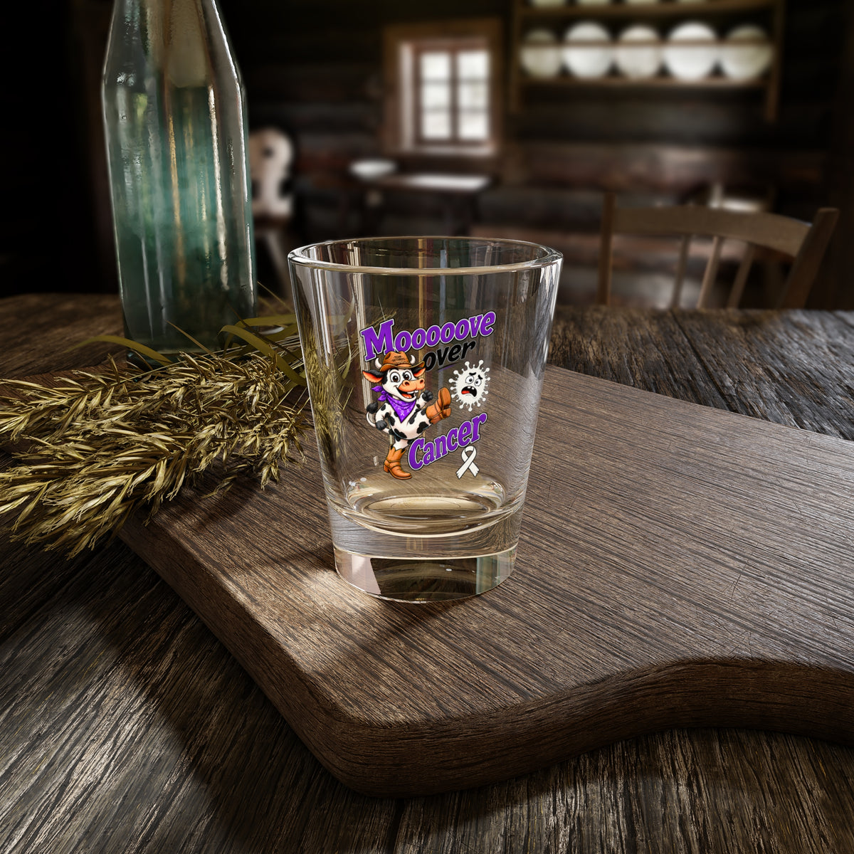 Moooove Over Cancer shot glass with cow artwork on a rustic wood table