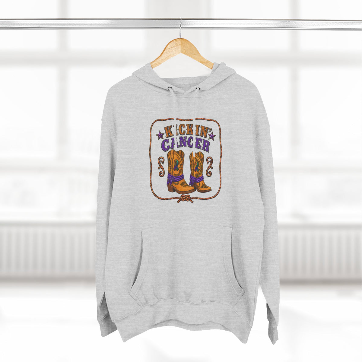 Gray Kickin' Cancer hoodie hanging from a wooden hanger
