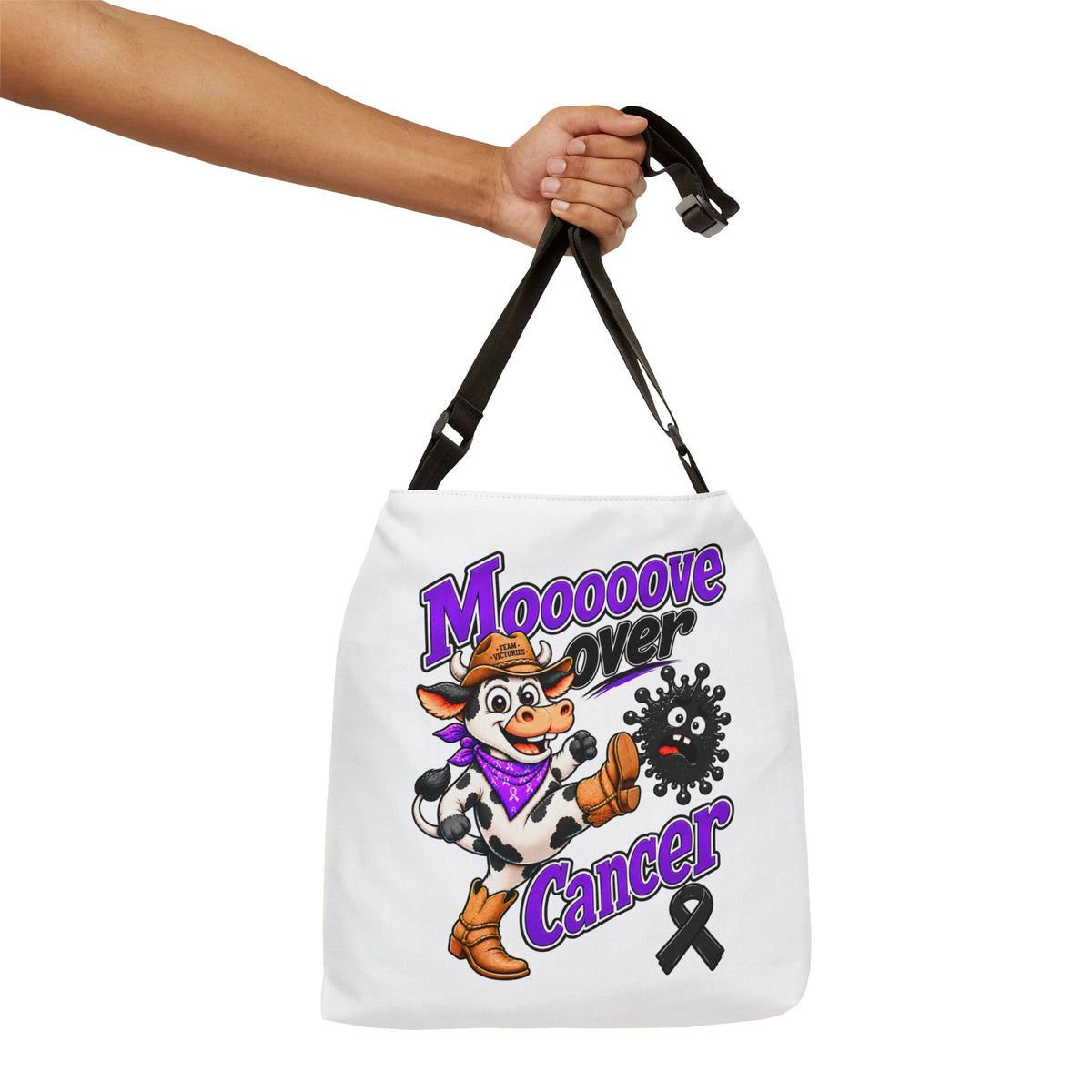 Person holding Moooove Over Cancer tote with adjustable strap and awareness artwork