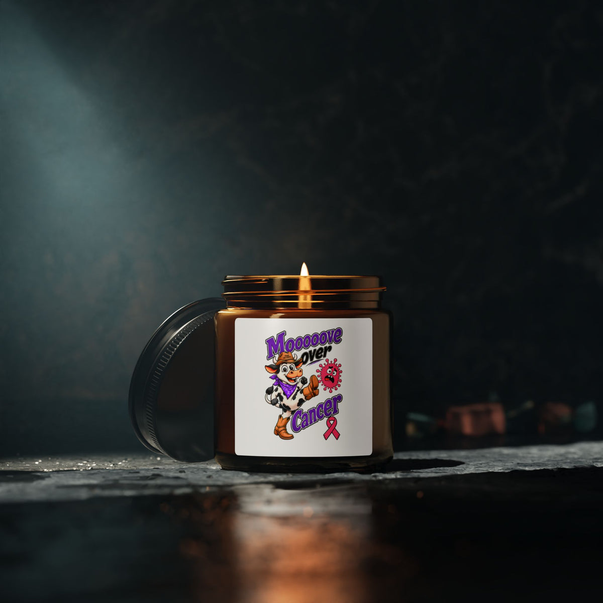 Moooove Over Cancer candle with lid beside it, featuring a pink Breast Cancer awareness ribbon