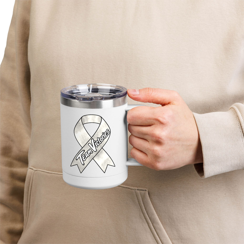Person holding a white Team Victories mug with a Lung Cancer awareness ribbon