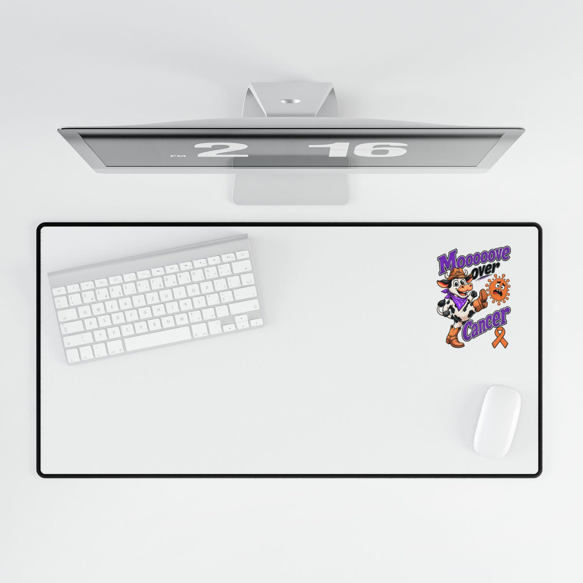 Moooove Over Cancer desk mat displayed beneath a monitor with keyboard and mouse