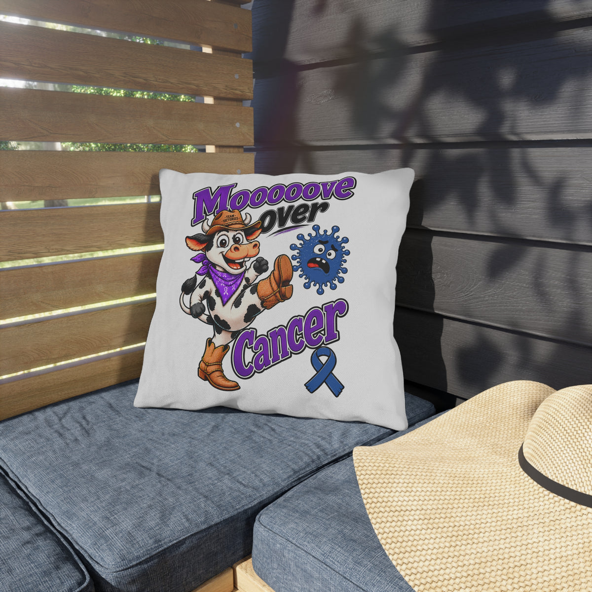 Moooove Over Cancer outdoor pillow on a cushioned patio chair