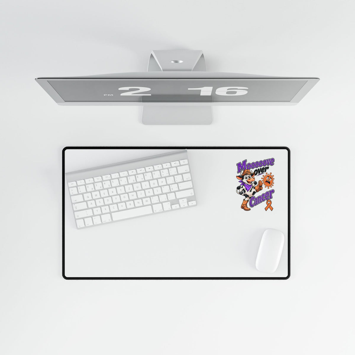 Moooove Over Cancer desk mat shown beneath a monitor in a top-down workspace view