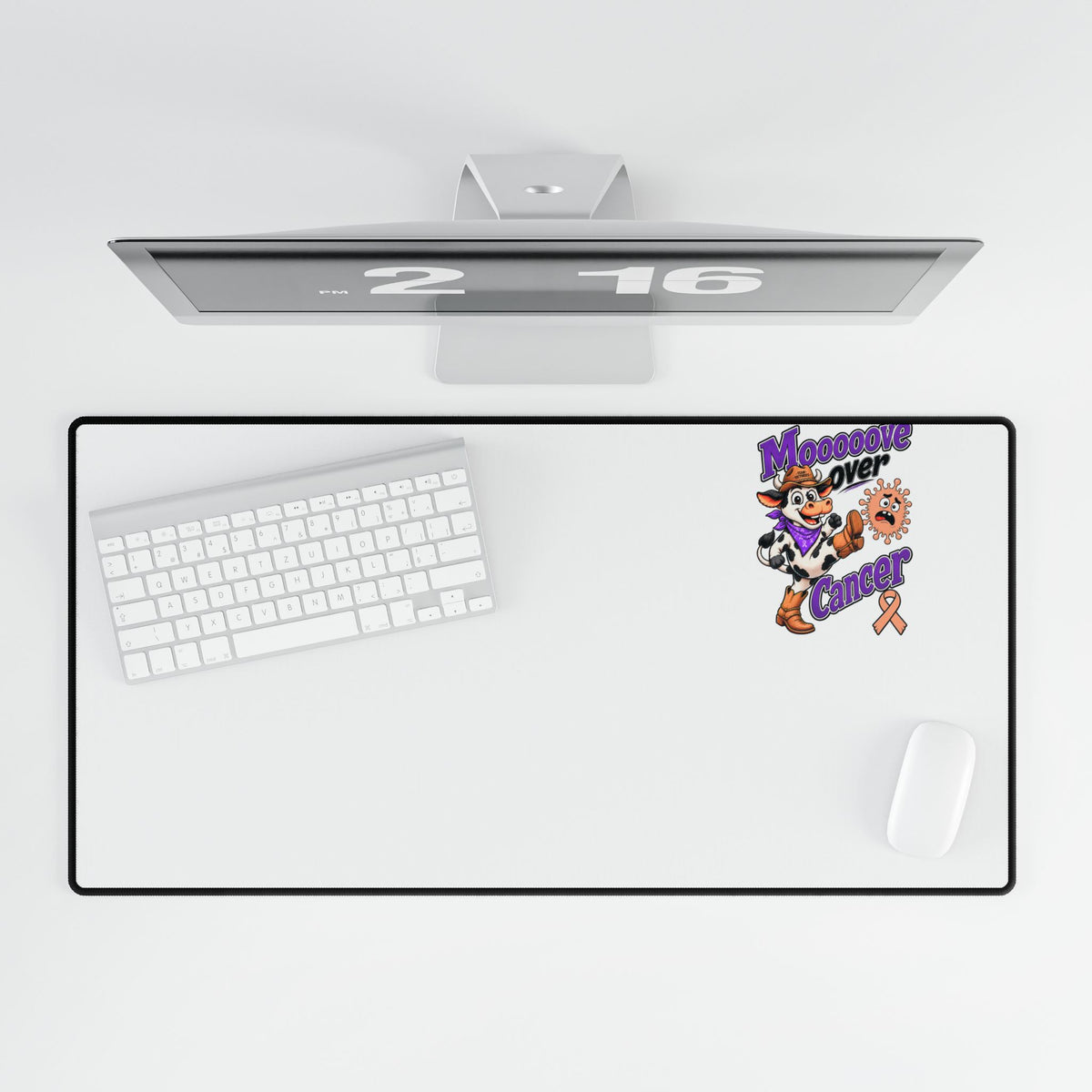 Top view of Moooove Over Cancer desk mat beneath a monitor, keyboard, and mouse