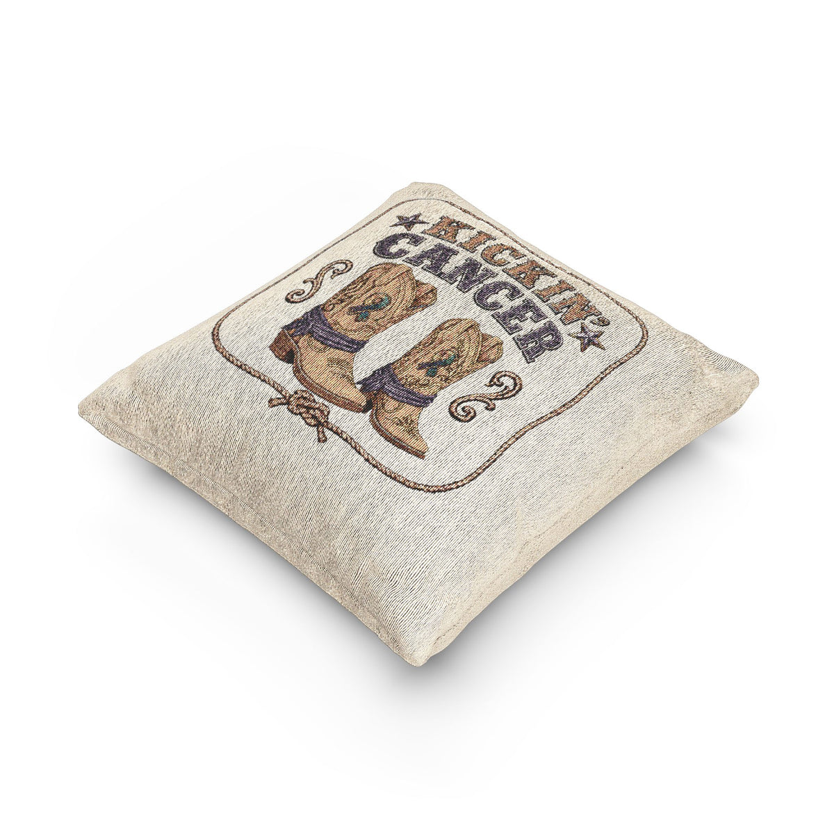 Angled view of a beige woven Kickin' Cancer pillow with cowboy boots and stitched edges