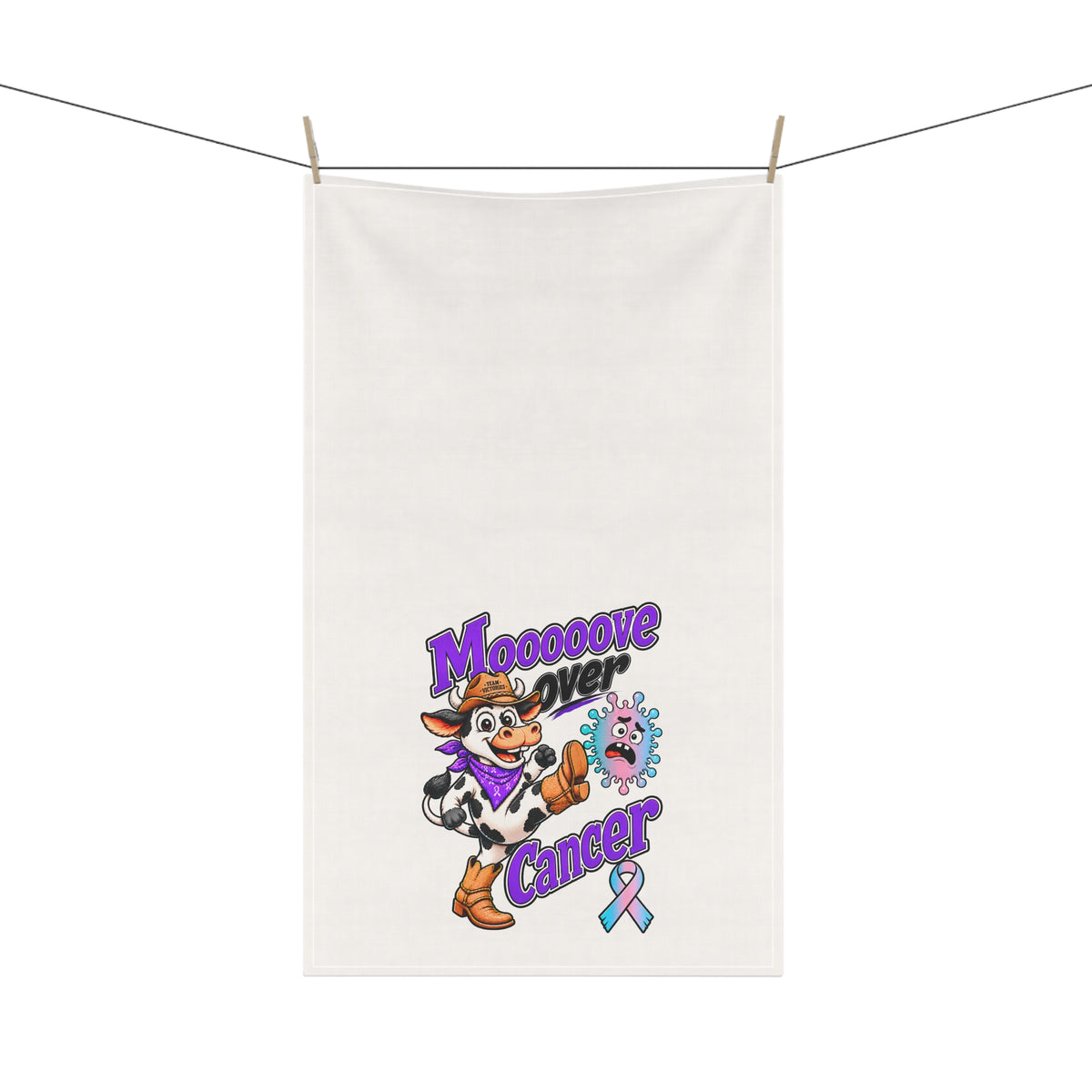 Moooove Over Cancer tea towel hanging outdoors with cow artwork and awareness ribbon
