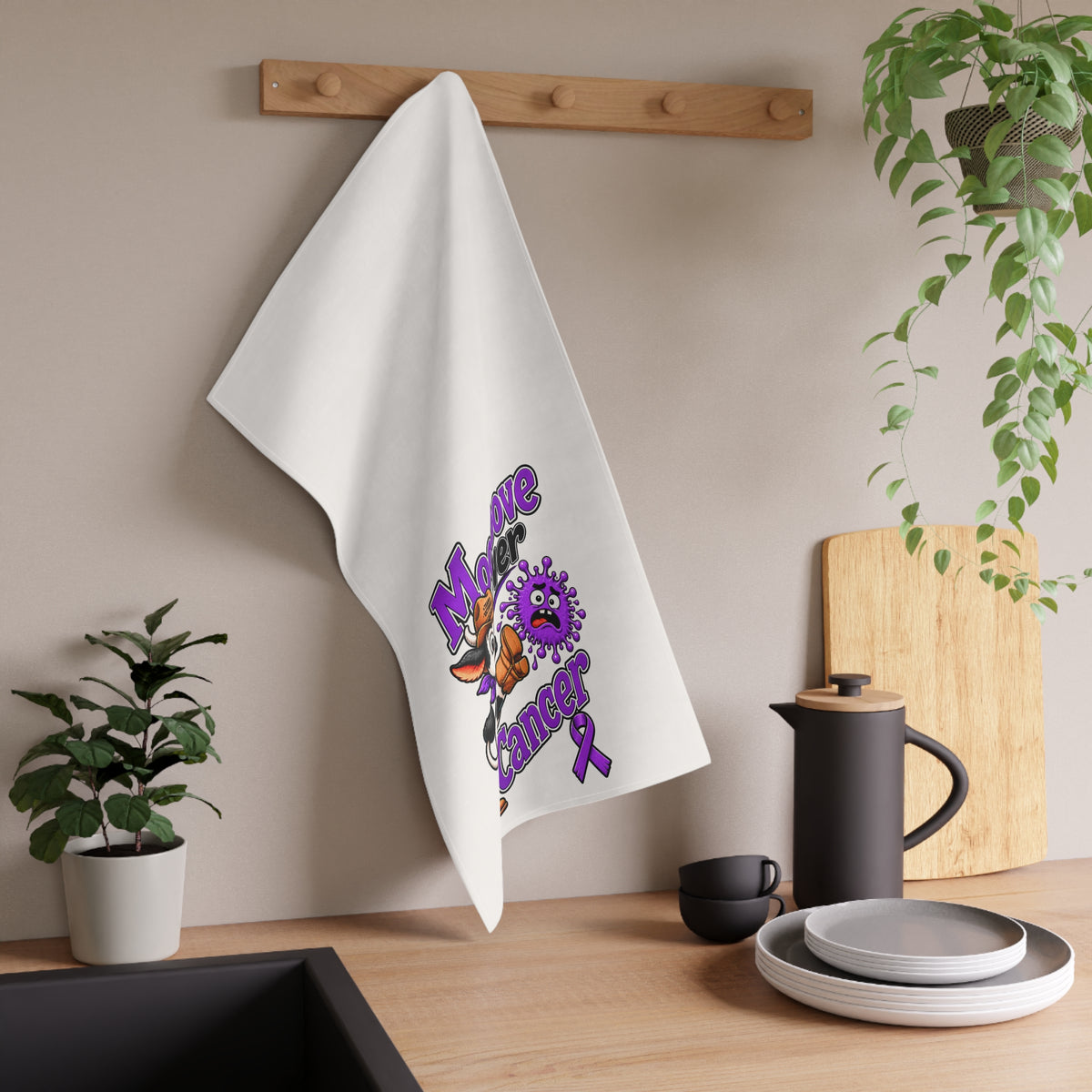 Moooove Over Cancer tea towel hanging in a kitchen with colorful cow and purple ribbon