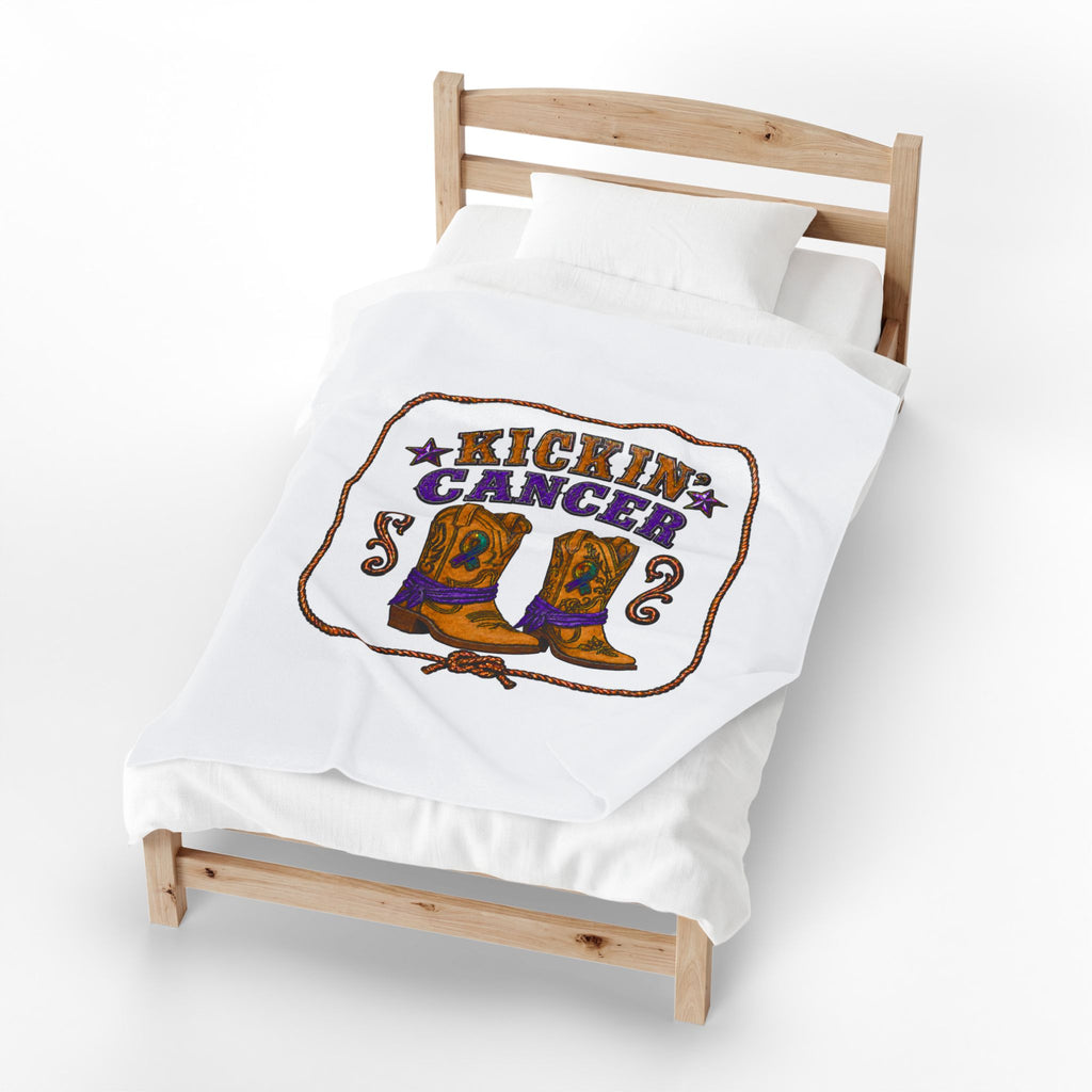 White Kickin' Cancer blanket displayed on a bed with a vertical western boot design