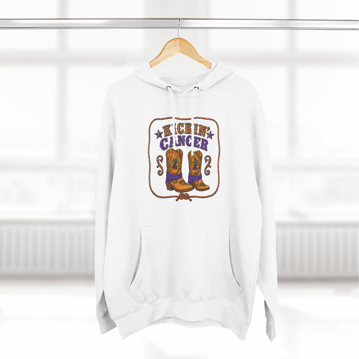 White Kickin' Cancer hoodie hanging from a wooden hanger