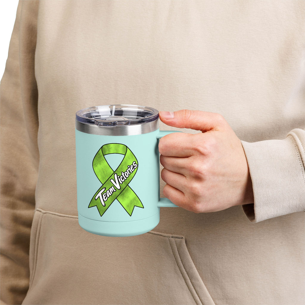 Person holding aqua Team Victories mug with Non-Hodgkin/Lymphoma Cancer awareness ribbon